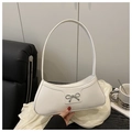 Detailed view of white croissant bag with silver bow accent and minimalist shoulder strap - White