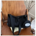 Détail du cabas en nylon noir avec large bandoulière et porte-monnaie sur chaise - Noir