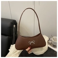 Detail of a brown leather bag with a silver metal bow buckle and a slim shoulder strap - Coffee