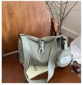 Détail d'un sac cabas en nylon vert sauge avec pochette ronde sur une chaise en bois - Vert