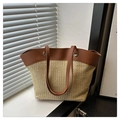 Close-up of woven straw tote bag featuring brown leather handles and metal hardware - Large / Beige Brown