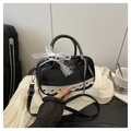 Dettaglio della borsa bowling in pelle nera con fiocco in pizzo bianco e tracolla regolabile - Nero