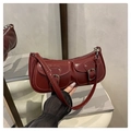 Close-up of vintage dark red patent leather handbag with dual front buckle pockets - Red