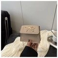 Detail einer beigen Mini-Tasche mit goldener Schleifenschnalle und Kettenriemen - Khaki