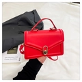 Borsa a tracolla rossa con chiusura dorata su sfondo di moda urbana chic - Rosso