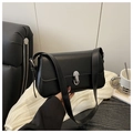 Detalle de bolso de hombro minimalista negro con cierre de giro plateado y correa ajustable - Negro