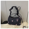 Detalle del bolso hobo de mezclilla azul con rosas y asa fruncida tipo scrunchie - Negro