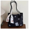 Detail van zwarte bloemen shopper met gevlochten handvatten en decoratieve sjaal op tafel - Zwart