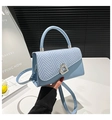 Dettaglio della borsa a tracolla azzurra con patta intrecciata e chiusura a cuore - Blu