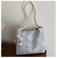 Detail van lichtblauwe bloemen tote bag met geweven handvaten en decoratieve zijden sjaal - Blauw