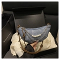 Borsa a mezzaluna in denim blu con catena d'argento e perle bianche su tessuto bianco - Blu