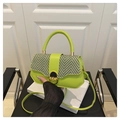 Detail van limoengroene crossbodytas met zwart-wit geweven klep en metalen sluiting - Groen
