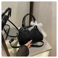 Dettaglio borsa Boston in pelle nera con cuori goffrati e fiocco in pizzo sulla maniglia - Nero