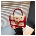 Vista detallada de mini bolso bandolera con estampado de cerezas, asa roja y broche dorado - Rojo
