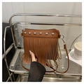 Close-up of brown fringe shoulder bag with silver rivets on a metallic display stand - Brown