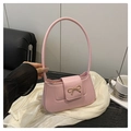 Détail d'un sac à bandoulière rose avec un nœud doré et une texture en cuir élégante - Rose