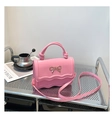 Detail of pink bow-knot bag showing wavy flap design and polished gold hardware detail - Pink