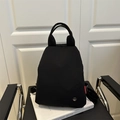 Versatile black canvas backpack and handbag with a modern metal logo and red label detail - Black