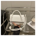 Witte mini handtas met gouden logo en geknoopte schouderband in een moderne setting - Wit