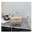Détail du sac à main blanc crème avec nœud doré et rabat aux bords ondulés - Kaki