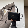Dettaglio di borsa nera con scritte dorate e texture in materiali misti di lusso - Nero