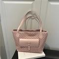 Borsa tote rosa con motivi a griglia geometrica e tasca frontale appoggiata su libri - Rosa