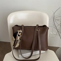 Borsa tote marrone scuro con cuciture bianche e sciarpa di seta su sedia moderna - Marrone Scuro