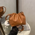Brown pleated drawstring bucket bag with gold lettering and a white plush keychain - Brown with Pendant