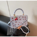 Detail der hellblauen Handtasche mit Kirschdruck und gewebtem Griff auf Designbüchern - Blau