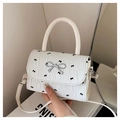 White mini square bag with black bow print and silver metal bow clasp details - White