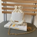 Detail view of white bucket bag with polka dot texture, pearl handle and gold chain - White
