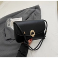 Detalle de bolso cuadrado de cuero negro con hebilla dorada y costuras de calidad - Negro