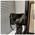 Detalle de bolso bandolera de ecopiel negra con textura de serpiente y hebilla dorada - Negro