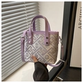 Dettaglio di ricami viola e rivetti argentati su una borsa a secchiello stile vintage - Viola