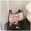 Détail du sac à bandoulière plissé rose avec motifs de nœuds noirs et boucle métallique - Motif de Nœud