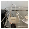 Detail van de tweekleurige hobo-tas met geweven textuur en gouden gesp op een displayrek - Wit