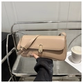 Detalle del bolso baguette beige con cierre ovalado dorado y piel lisa suave - Caqui