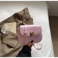 Detailansicht einer rosa Lackleder-Satteltasche mit goldenem Herzverschluss und Kettenriemen - Rosa