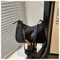 Detail of black crocodile-embossed leather hobo bag with sleek gold-tone metal hardware - Black