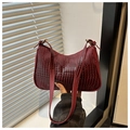 Detail of burgundy crocodile-embossed leather underarm bag with vintage gold buckle - Red