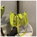 Primer plano de lentejuelas verde neón y hebilla de metal en un bolso baguette de moda - Verde