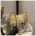 Detalle de costuras de lentejuelas y hebilla de metal dorado en bolso de hombro - Dorado