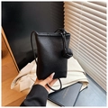 Close-up of black litchi pattern mini bag with unique ball-knotted shoulder strap detail - Black