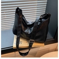 Detail of black faux leather tote bag with soft texture and adjustable silver buckle strap - Black