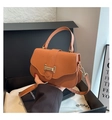 Dettaglio di una borsa in pelle marrone con fibbia metallica a H e tracolla rimovibile - Marrone