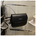 Classic black woven texture crossbody bag with gold lettering on a stylish shelf - Black