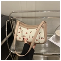 Detailansicht der cremeweißen Schultertasche mit Kirschmuster und Leder-Schultergurt - Khaki