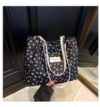 Detailaufnahme einer schwarzen Shopper-Tasche mit rosa Schleifen und weißen Riemen - Schwarz