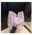 Detail of pink bow-print tote bag with quilted texture and white handles for women - Pink