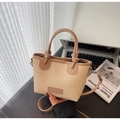 Detailed view of the woven straw tote bag with knot handle and adjustable crossbody leather strap - Khaki